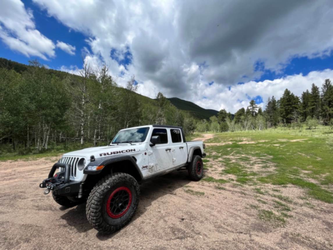Asbjørn Jeep Gladiator Rubicon front three-quarter in mountain clearing