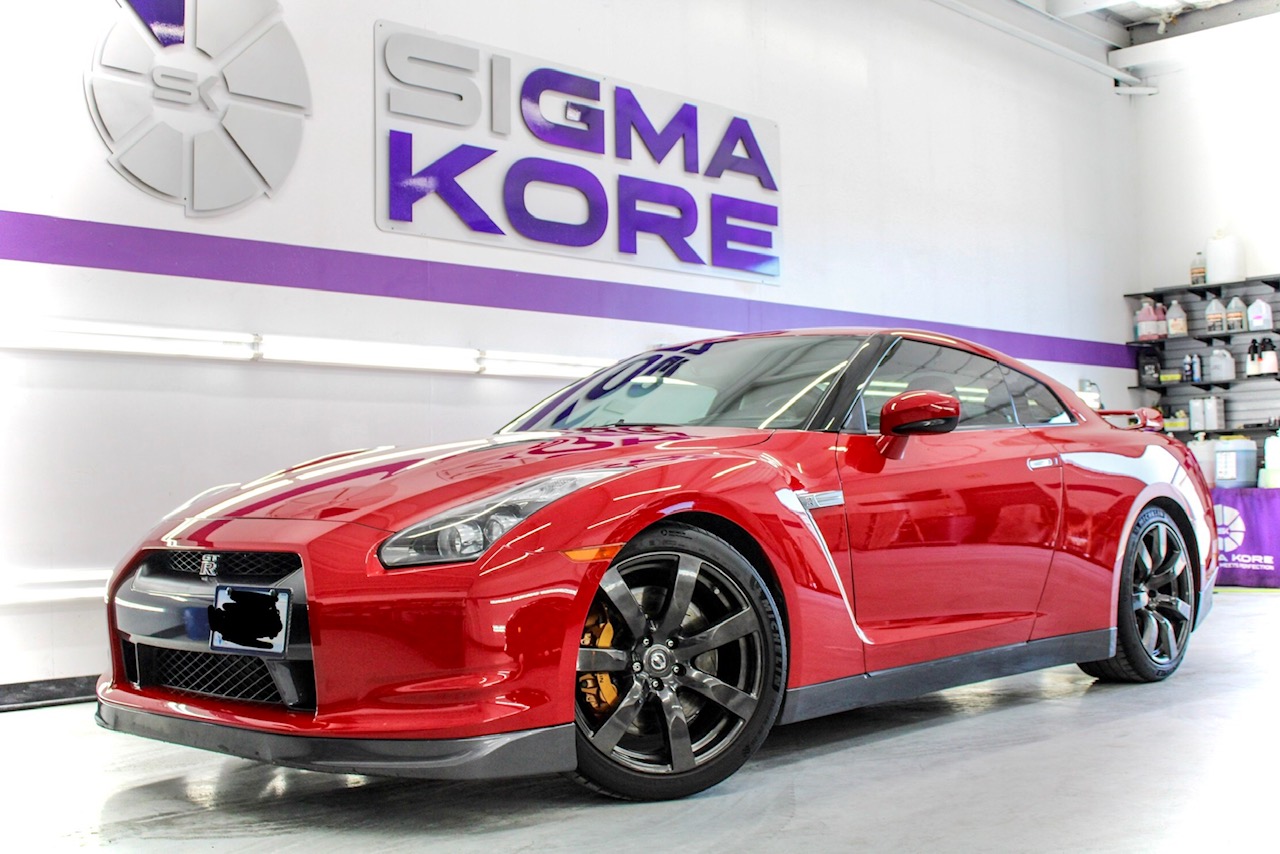 Red Nissan GT-R front three-quarter in detail bay