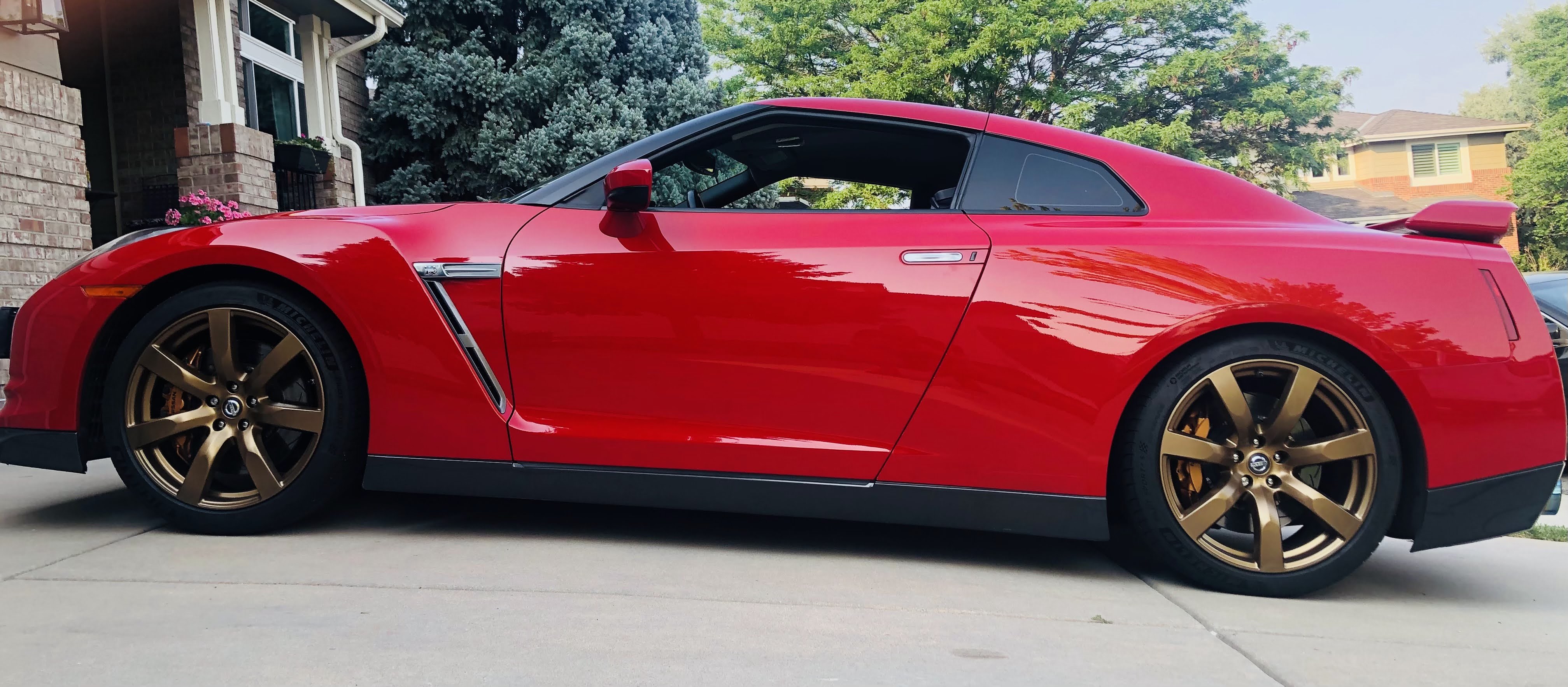 Side profile of red GT-R with bronze wheels